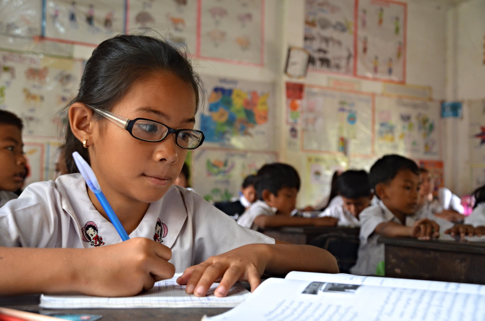 Young girl writing on her desk in primary school.  Cambodia, March 2015. Credit: GPE/Aya Kibesak