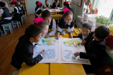 学生们正在阅读他们在老师的帮助下根据图书馆的书中发现的故事写的书。Dadal县,蒙古。