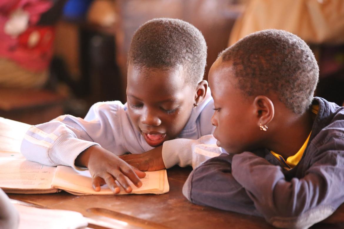 Deux jeunes filles lisant dans le même livre dans une école au Bénin. Crédit: GPE/Chantal Rigaud