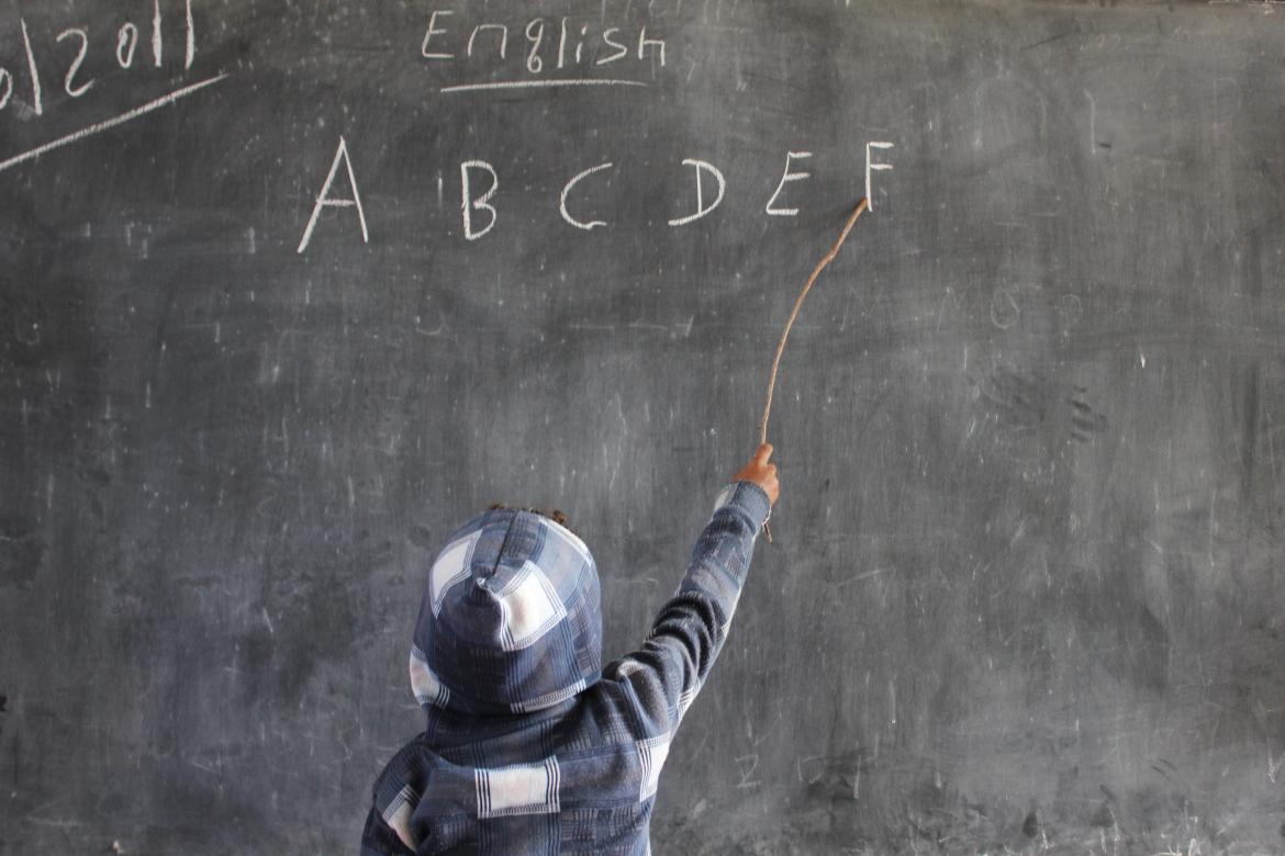 Un garçon lisant des lettres de l'alphabet écrites sur un tableau à l'école de Felege Abbay en Ethiopie. Crédit: PME/Carolina Valenzuela Un garçon lisant des lettres de l'alphabet écrites sur un tableau à l'école de Felege Abbay en Ethiopie. Crédit: PME/Carolina Valenzuela